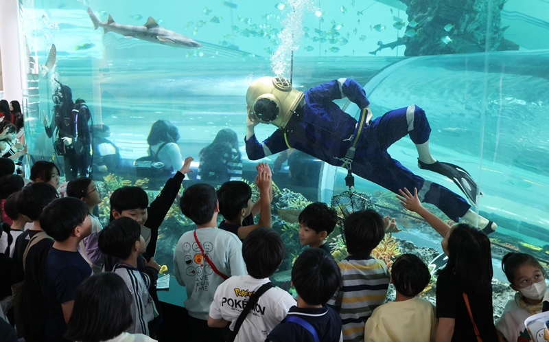 A diver strikes a pose on Nov. 5 in front of students after his underwater performance with the theme 